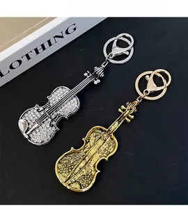 Detail of silver rhinestone and gold embossed violin keychains for handbags and gifts