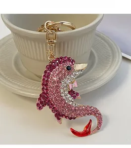 Detailansicht eines Delfin-Schlüsselanhängers mit rosa Kristallen und goldenem Karabinerverschluss