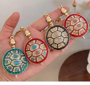 Détails de quatre porte-clés tortue ornés de pierres d'opale et de cristaux brillants