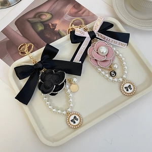 Porte-clés élégant avec camélia et perles et ruban à nœud pour décoration de sac