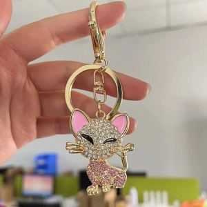 Sparkling kitten keychain with pink and white rhinestones and gold plating on hand