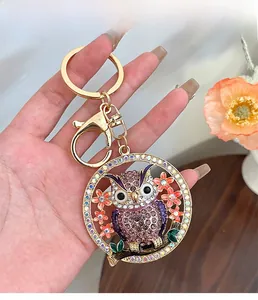 Détail du porte-clés hibou avec strass violets et fermoir mousqueton en métal doré