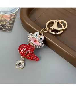 Detailed view of a gold-plated toad keychain with red crystals and coin pendant