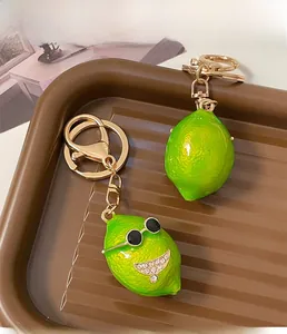 Detail of green lemon keychain with sunglasses, rhinestones and golden metal ring clip
