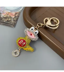 Close-up of golden zodiac snake keychain with rhinestones and a lucky coin charm