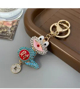 Close-up of golden lucky frog keychain featuring blue rhinestones and cai character