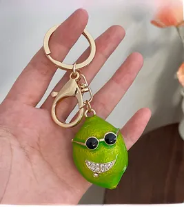Close-up of cute green lemon keychain with sunglasses and rhinestone smile decoration