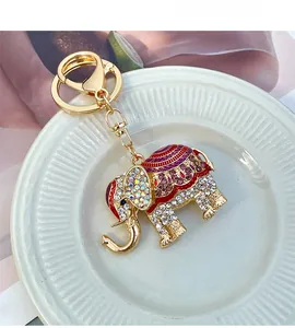 Detail of crystal-encrusted elephant keychain with colorful enamel on a white plate