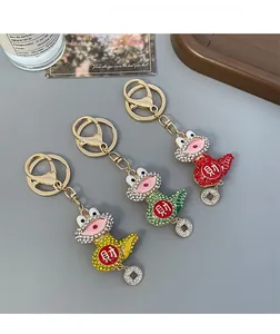 Detailed macro view of three crystal-encrusted snake keychains in yellow, green, and red