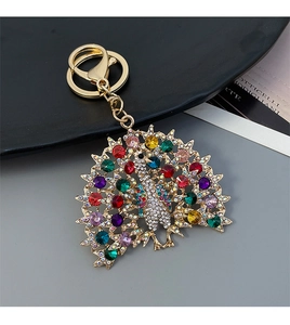Detail of colorful rhinestones on a golden peacock keychain and car bag pendant