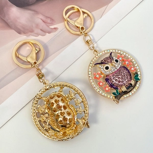 Porte-clés hibou scintillant avec strass colorés sur une branche en métal doré