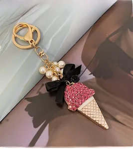 Détail du porte-clés crème glacée en strass roses avec perles et nœud noir élégant