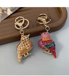 Detailansicht goldener Eulenanhänger und bunter Papageien-Schlüsselanhänger mit Glitzersteinen