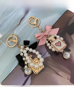 Detail of luxury perfume bottle keychain with handmade bow, pearls and crystals