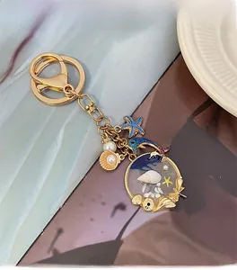 Detail of ocean-themed keychain with dolphin, starfish, and pearl shell pendants