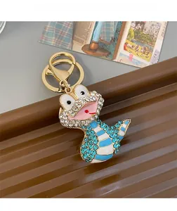 Gros plan d'un porte-clés serpent doré avec strass bleus et émail sur un plateau