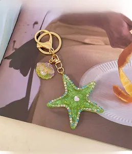 Detail of green starfish keychain with colorful rhinestones and purple shell charm