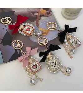 Detail of pearl perfume bottle keychains with bows and rhinestones in four colors