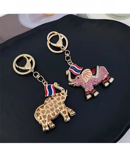 Detail of Thai elephant keychains with pink crystals, hollow heart, and national flag