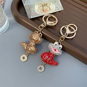 Exquisite gold hollow snake and red crystal monster keychain with lucky coin pendant