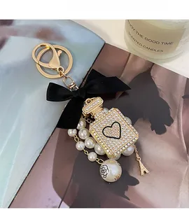 Detailed shot of bow keychain with pearl perfume bottle and Eiffel Tower charm on a magazine