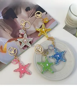Detail of starfish and shell keychains with rhinestones and golden metal rings