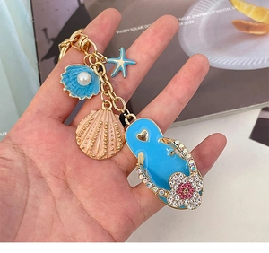 Detail of beach keychain featuring blue rhinestone flip flop and starfish charms
