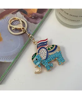 Detailed close-up of golden elephant keychain with sparkling blue crystals and Thailand text