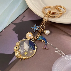 Cartoon ocean keychain with dolphin starfish and shell charms on golden alloy ring