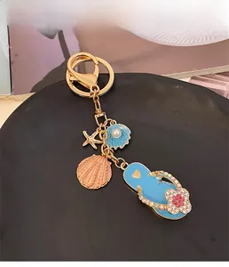 Detailed shot of ocean-themed keychain with blue flip-flop and shell pendants