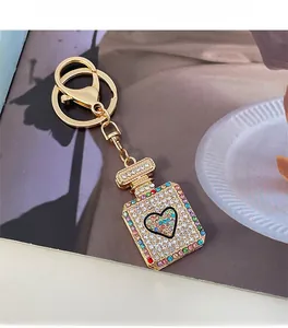 Macro shot of gold perfume bottle keychain with crystal heart and sparkling rhinestones