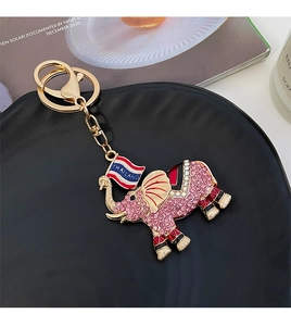 Detailed close-up of a gold elephant keychain with pink rhinestones and Thailand flag