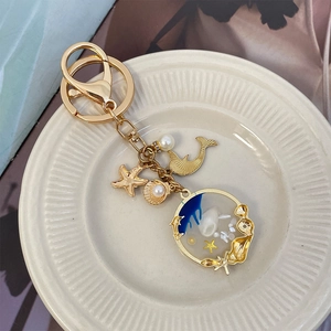 Golden ocean series keychain featuring shells, starfish, whale tail and pearl pendants