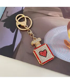 Detailed close-up of a sparkling rhinestone perfume bottle keychain with a red heart icon