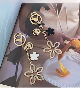 Detail of clover keychains with white rhinestones and LOVE FOREVER engraved charms