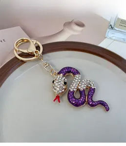 Detailansicht eines lila Schlangen-Schlüsselanhängers mit Kristallen und Goldclip