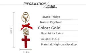 Detail view of red velvet bow and crystal cross keychain with pearl cluster charms