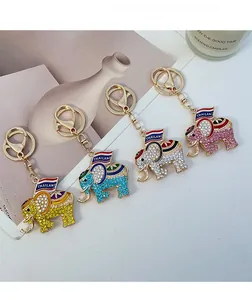 Detail of four crystal-encrusted elephant keychains with Thailand flag motif and gold clips