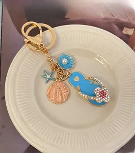 Detail of beach themed keychain with rhinestone flip flop, shell and blue starfish charms