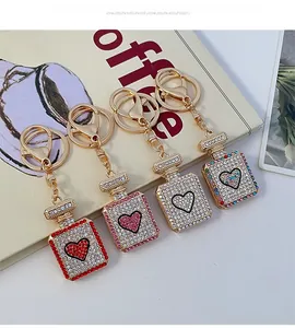 Detail of four crystal perfume bottle keychains in red, pink, white, and gradient colors