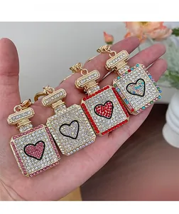 Detailed close-up of heart perfume bottle keychains with colorful crystal rhinestones