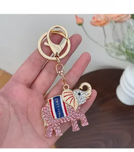 Détail d'un porte-clés éléphant doré avec strass roses et gravure de texte Thaïlande