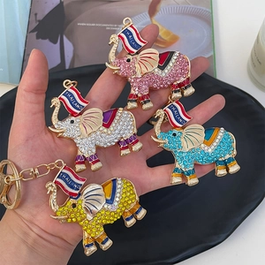 Handheld display of sparkling rhinestone Thai elephant keychain in four vibrant colors