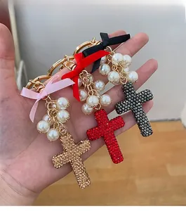 Close-up of sparkling rhinestone cross pendants with elegant pearl beads and silk ribbons