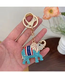 Vue détaillée d'un porte-clés éléphant doré de Thaïlande avec des cristaux bleus brillants