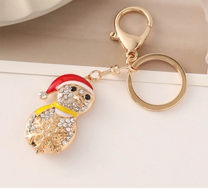 Macro view of gold-tone Christmas snowman keychain featuring sparkling rhinestones