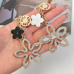 Elegant gold-plated clover earrings featuring sparkling rhinestones and enamel flower charms