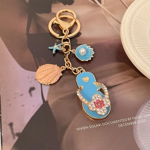 Marine theme keychain with four-leaf clover slipper charm and pearl shell on magazine