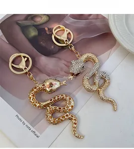 Détails de porte-clés serpent dorés avec texture d'écailles et strass blancs scintillants