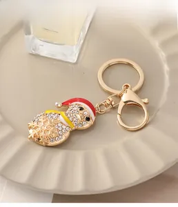 Detailed view of a sparkling rhinestone snowman keychain with red and white enamel on a tray